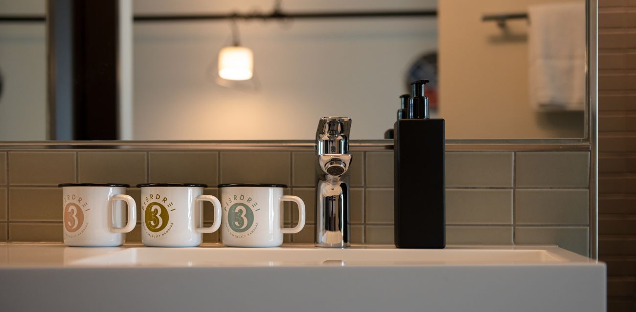 Washbasin with three PIERDREI enamel cups and PIERDREI soap dispenser