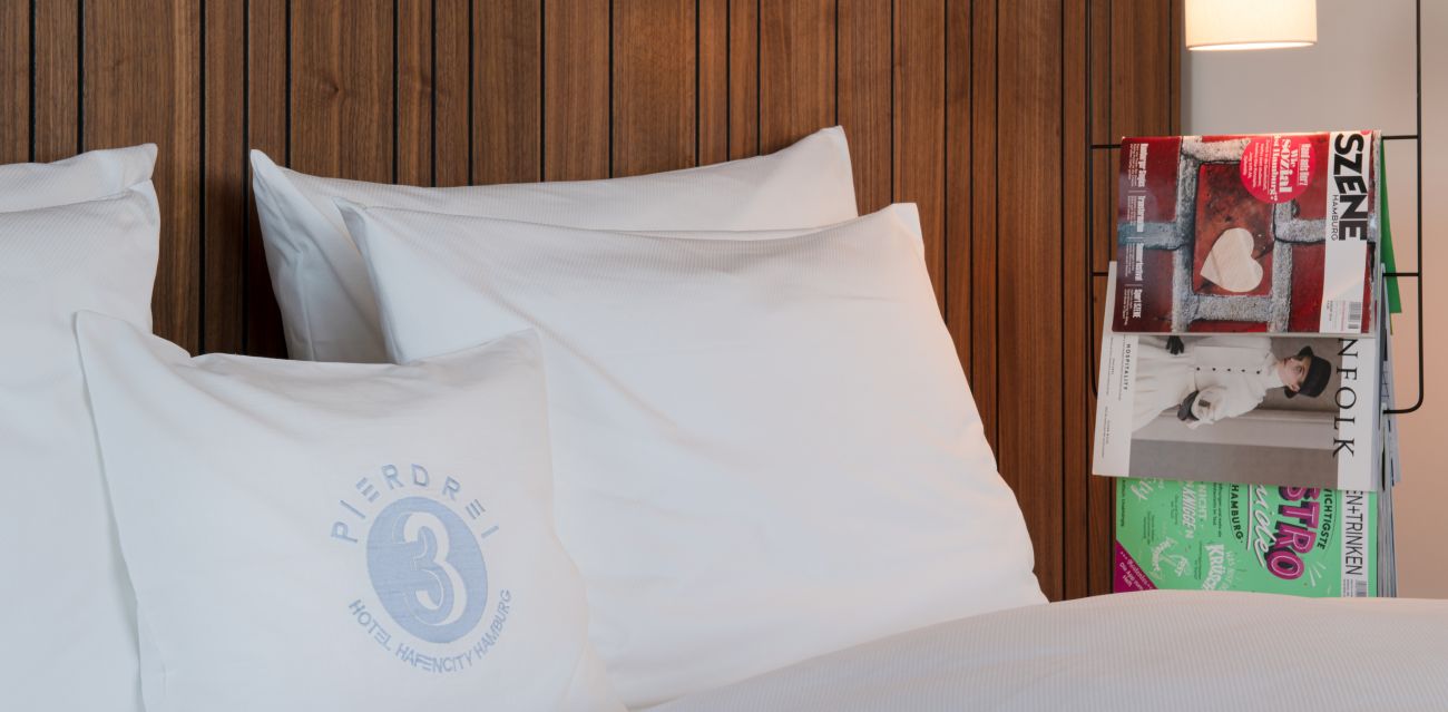 Close-up of a bed, next to it magazines