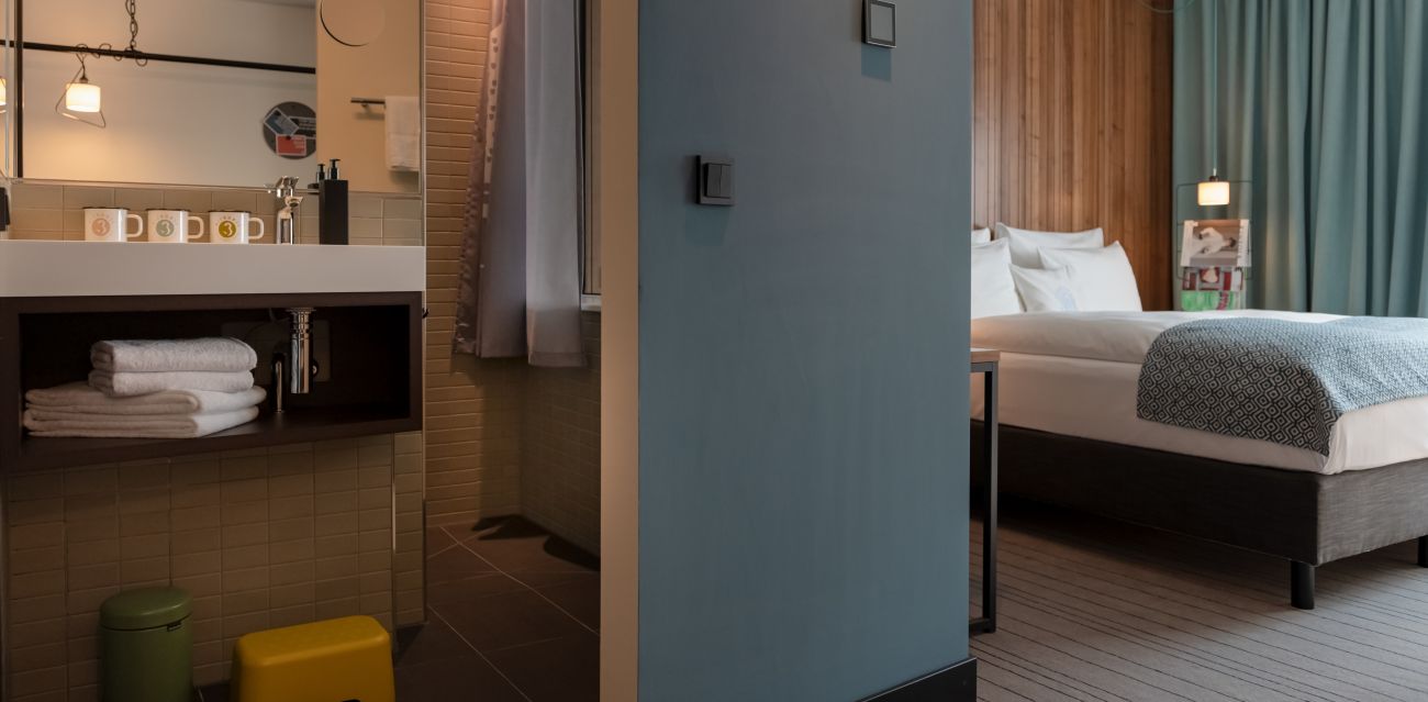 View into a MEDIUM PLUS room with sleeping area and open bathroom