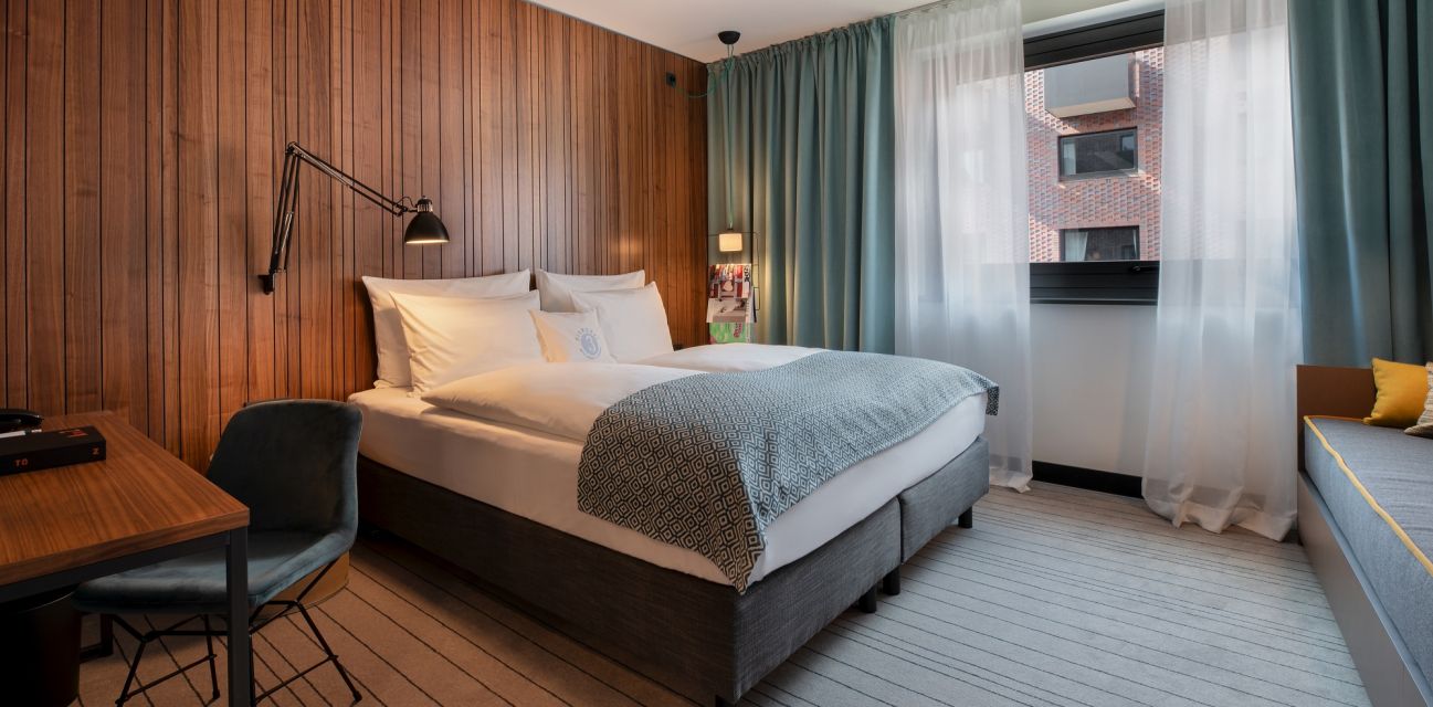 View into a MEDIUM PLUS room with sleeping area and open bathroom